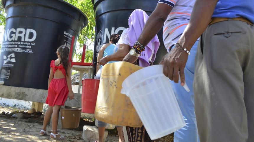 Algunos residentes hacen fila en espera de agua. Néstor De Ávila